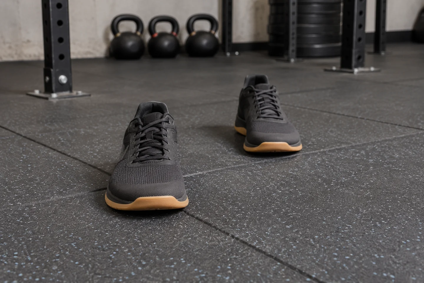 Two flat training shoes positioned in a staggered stance on rubber flooring.