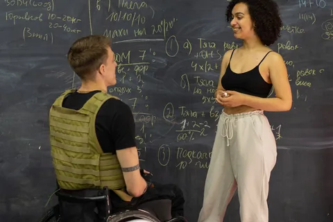A trainer and gym user talking beside a whiteboard.