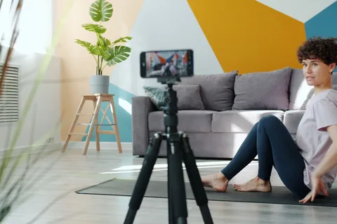 A phone on a tripod recording a home exercise space.