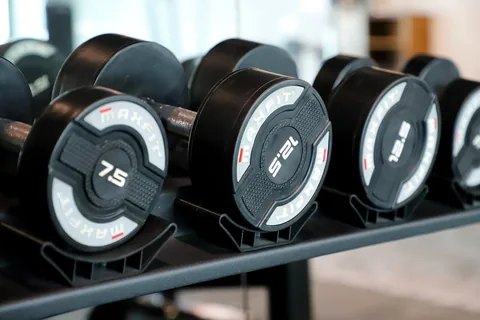 Weight markings on dumbbells in a rack.