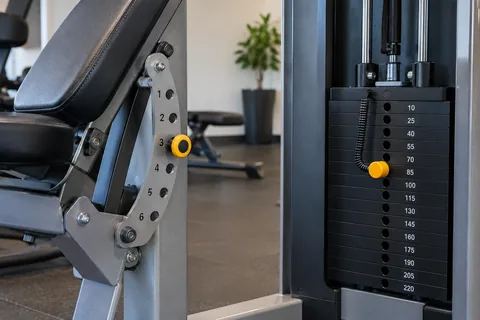 Two different gym adjustment mechanisms, a bench support and a selector weight stack.