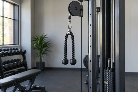 Cable station with rope attachment hanging from high pulley.